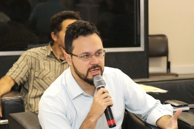 Participante do público faz pergunta aos expositores do evento