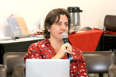 Camila D’Ottaviano faz perguntas aos expositores durante o debate
