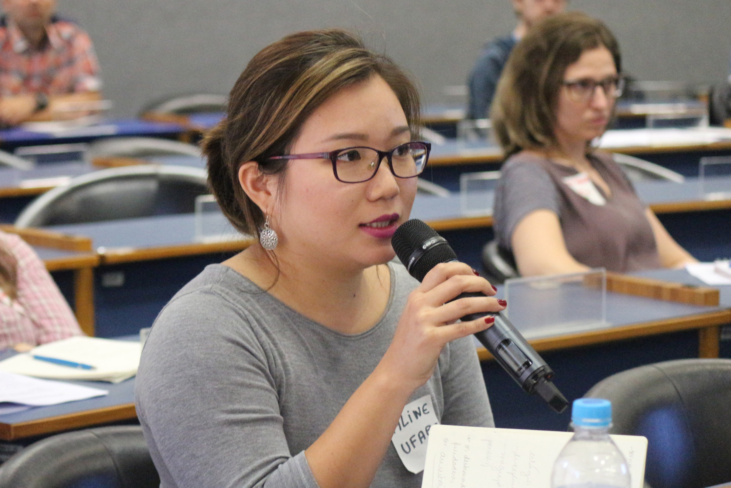 Aline Yuri Hasegawa faz perguntas ao expositor durante o debate