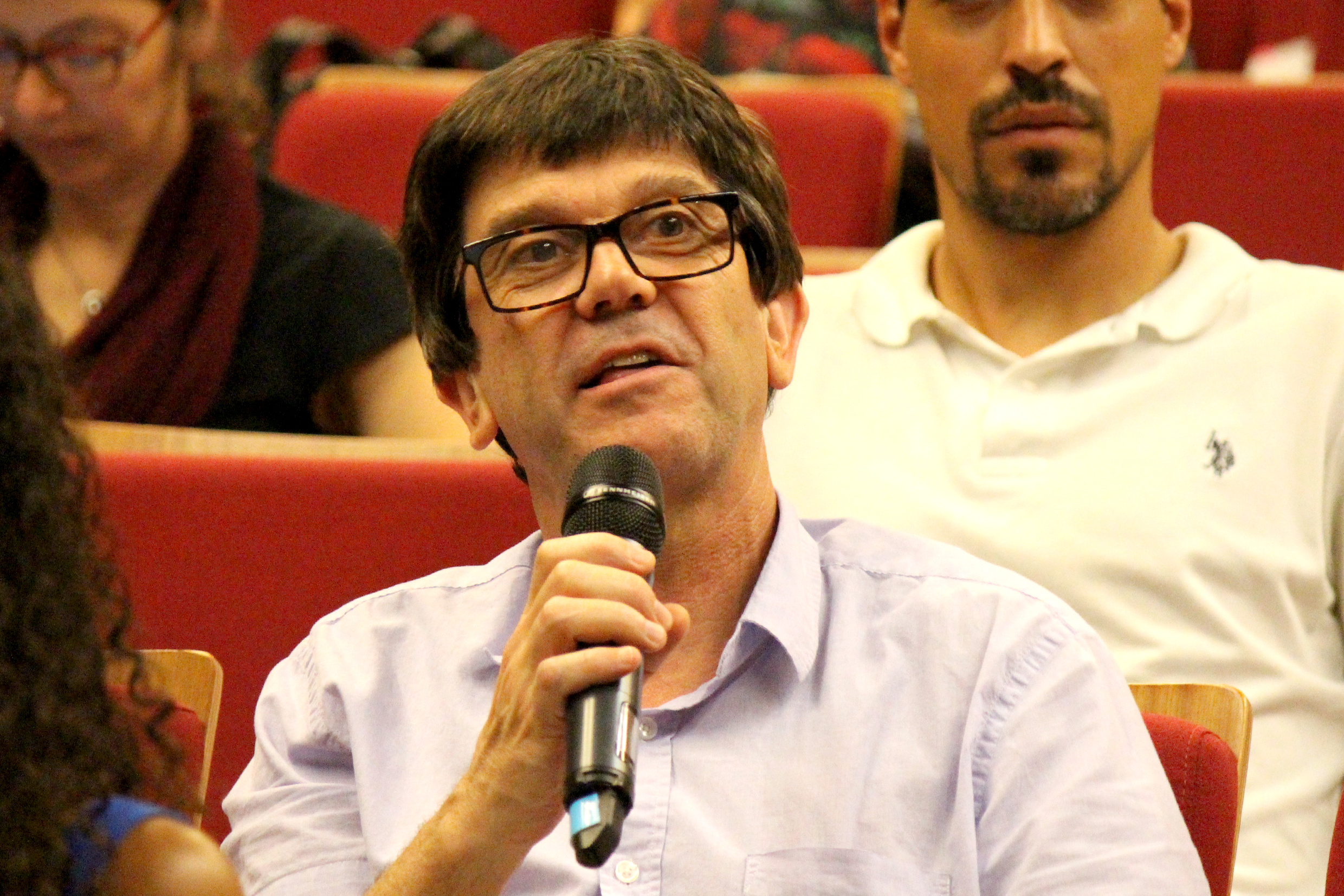 Participante do público faz perguntas aos expositores durante o debate