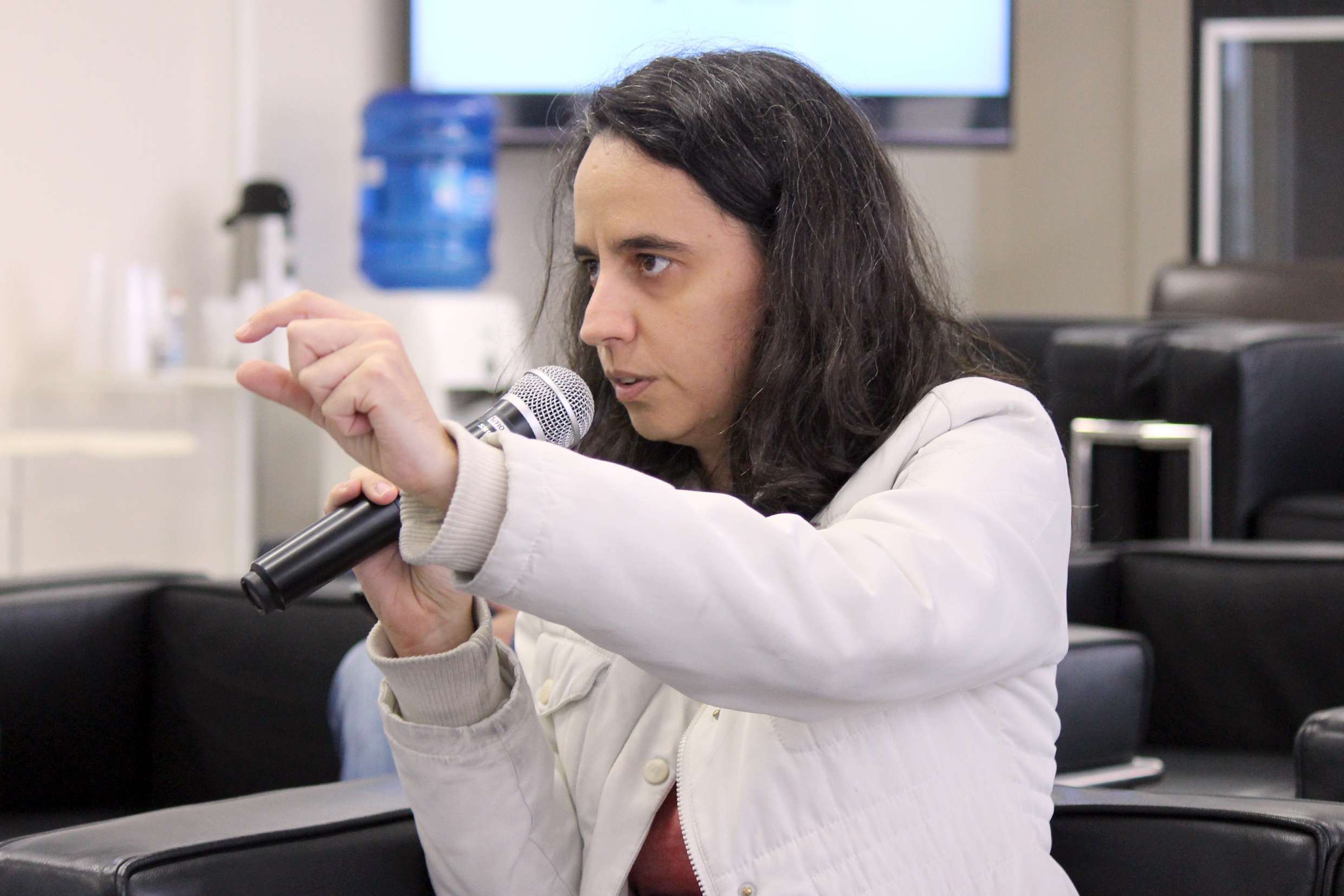 participante do público faz perguntas aos expositores