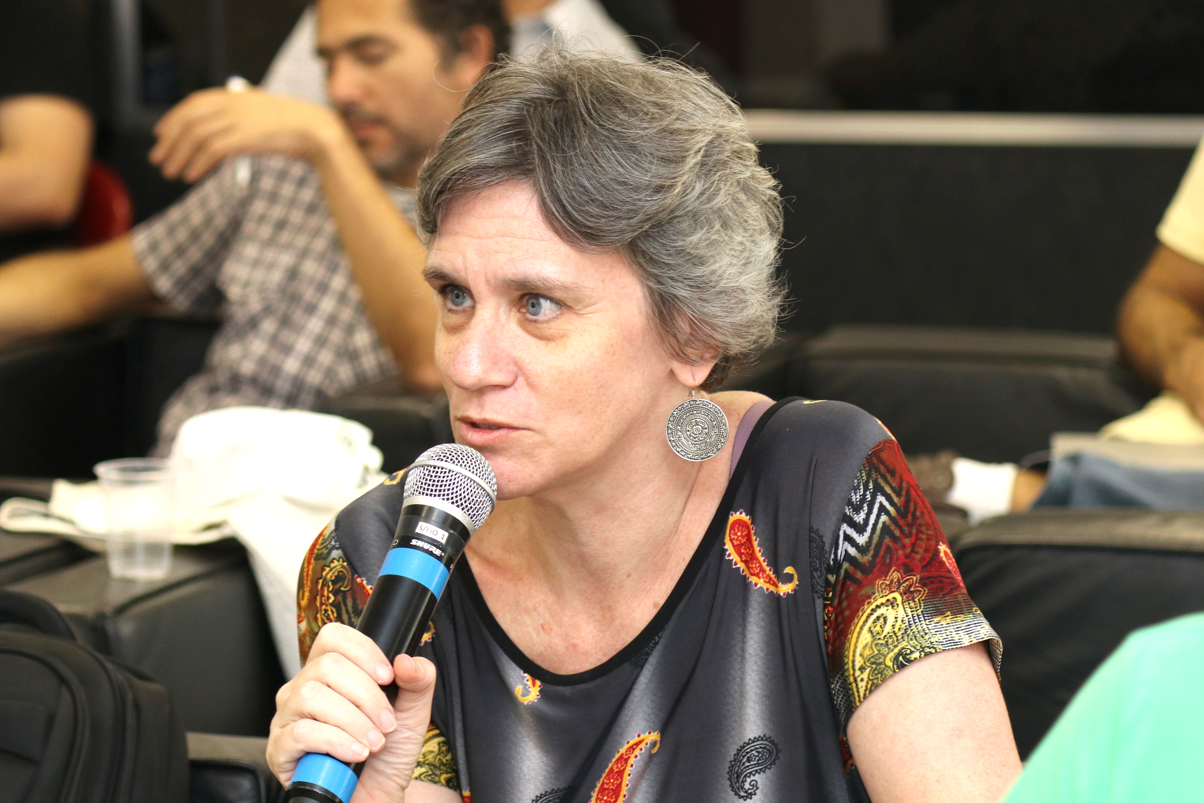 Participante do público faz pergunta aos expositores