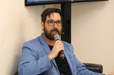 Participante do público faz pergunta aos expositores