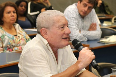 Participante do público faz pergunta aos expositores