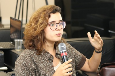 Participante do público faz pergunta aos expositores