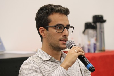 Participante do público faz pergunta aos expositores