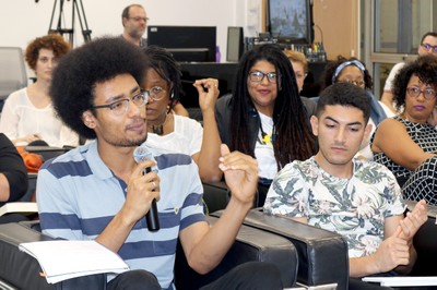 Participante do público faz perguntas aos expositores durante o debate