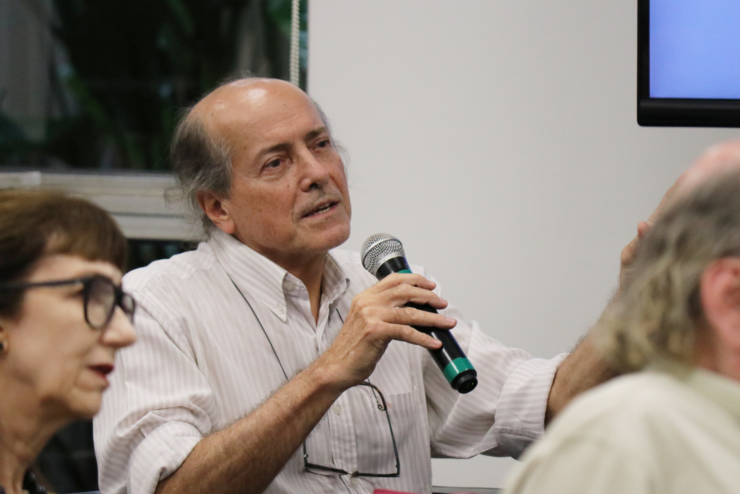 Participante do público faz pergunta aos expositores