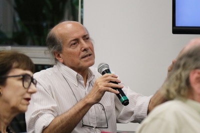 Participante do público faz pergunta aos expositores
