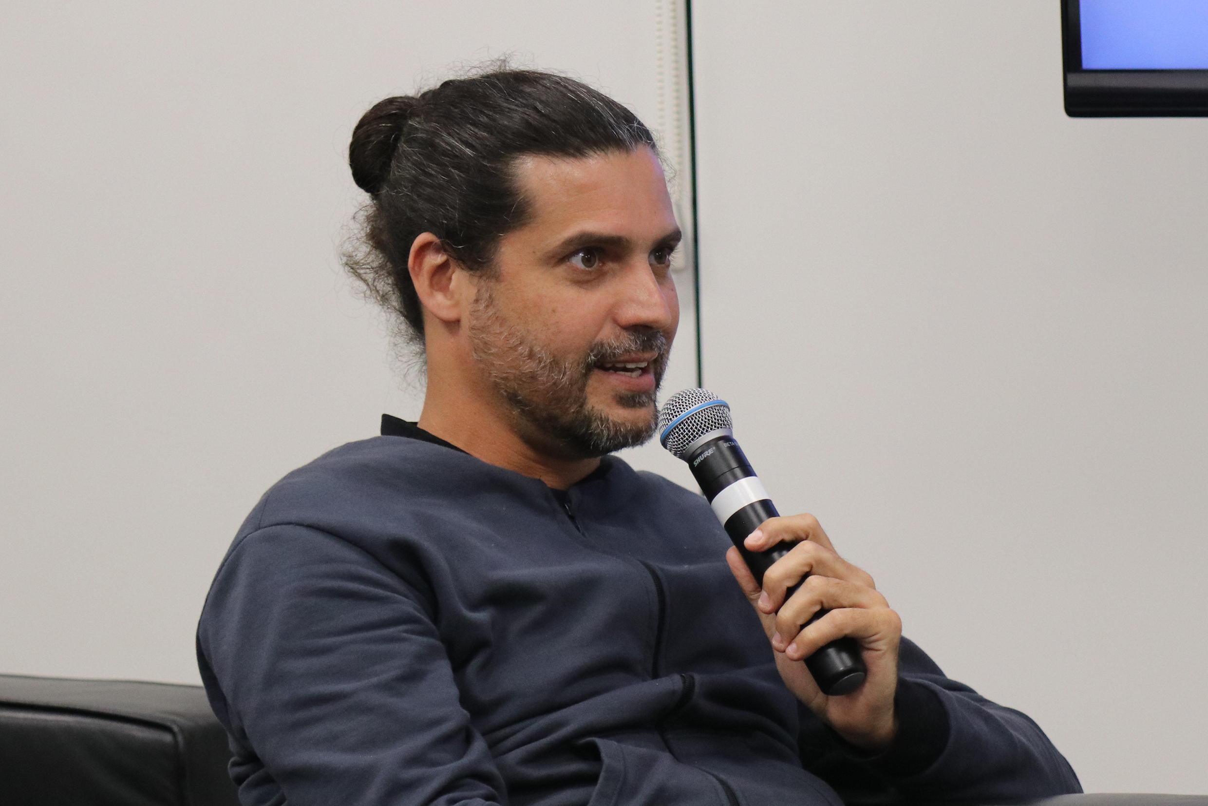 Participante do público faz pergunta aos expositores