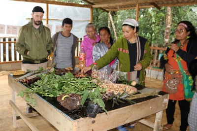 Jera Guarani mostra aos convidados algumas plantas, batatas e milhos, cultivados na aldeia Kalipety
