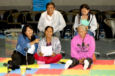 Francy Baniwa, Maria Bidoca, Bibiana Fontes sentadas no chão, e atrás, sentados na cadeira, Francisco Fontes e Larissa Fontes 